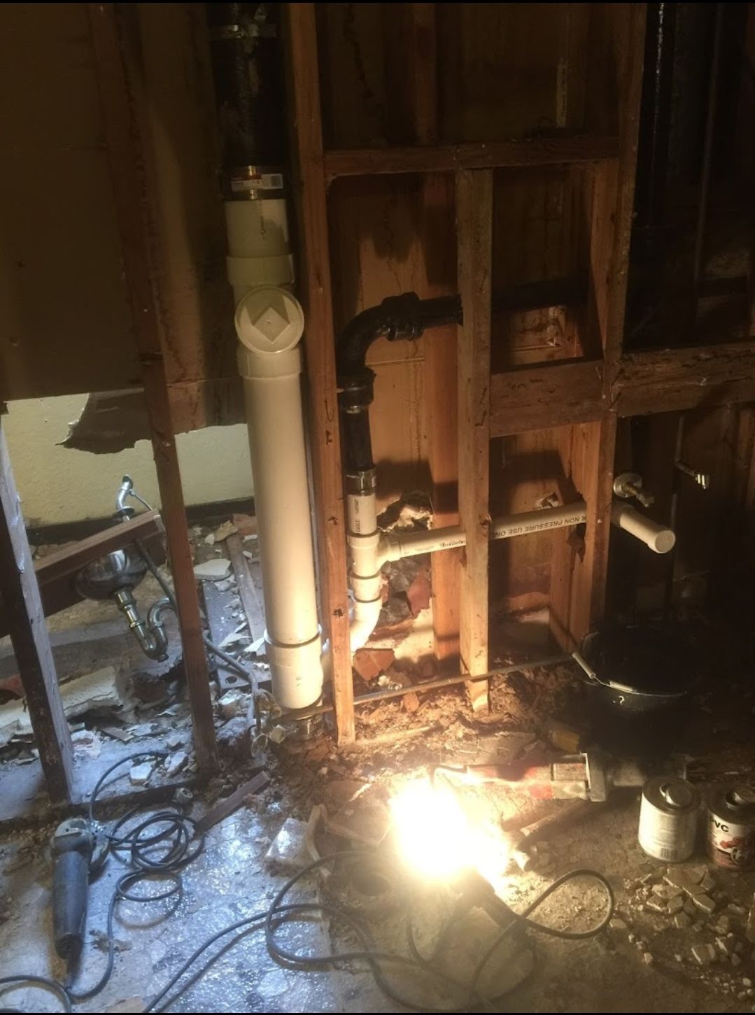 A room with a lot of pipes in it and a light on the floor.