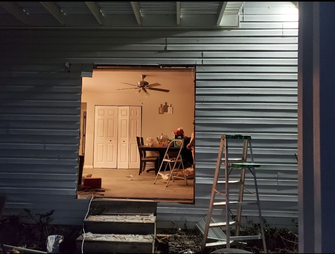 A ladder is sitting in front of a house that is being remodeled.