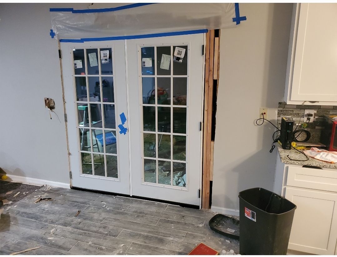 A french door is being installed in a kitchen.