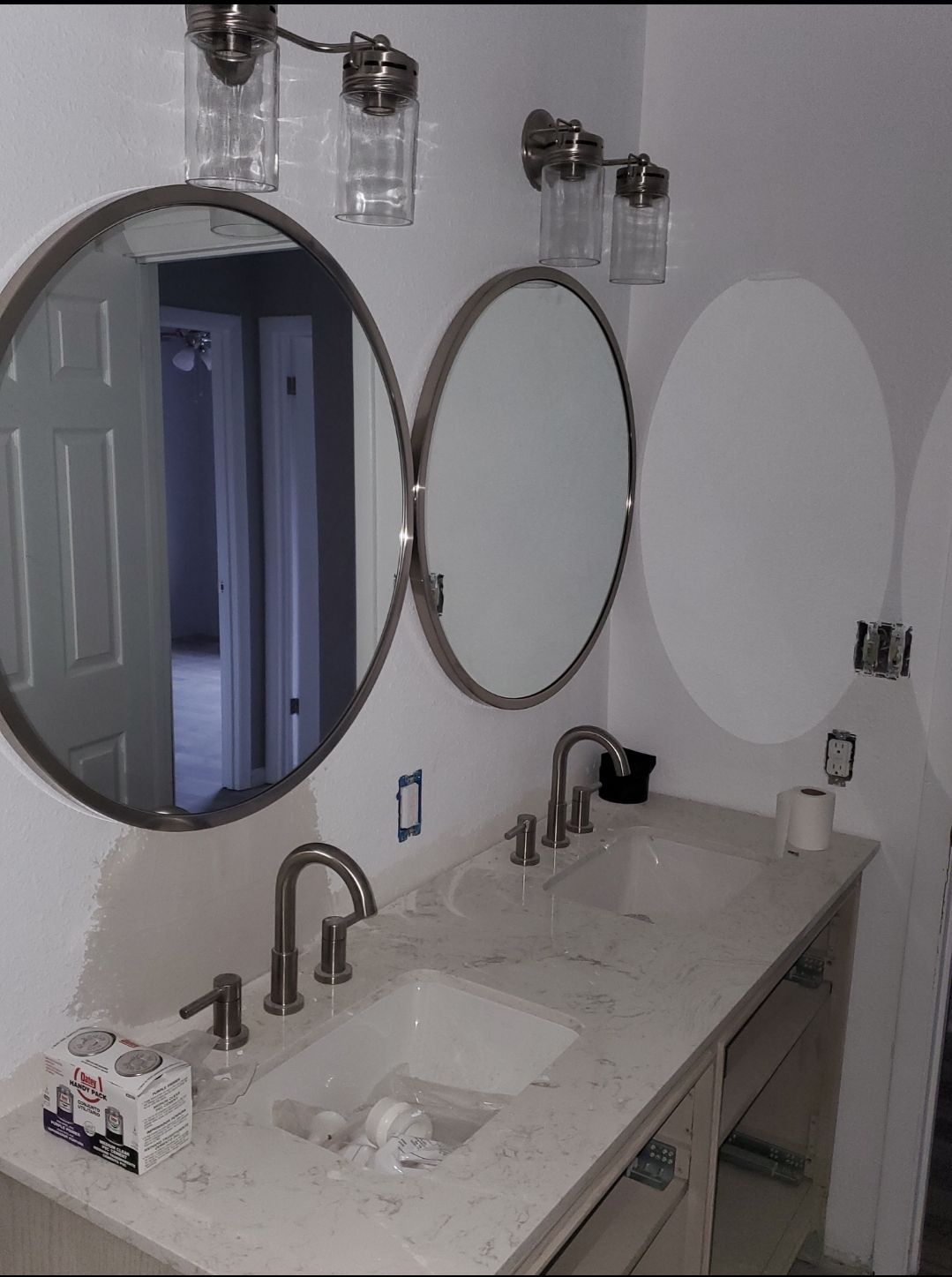 A bathroom with two round mirrors and a sink
