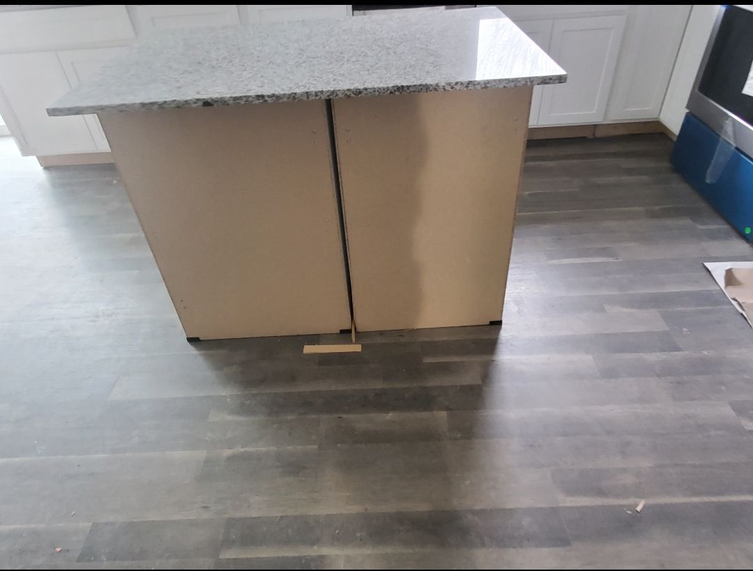 A kitchen island with a granite counter top