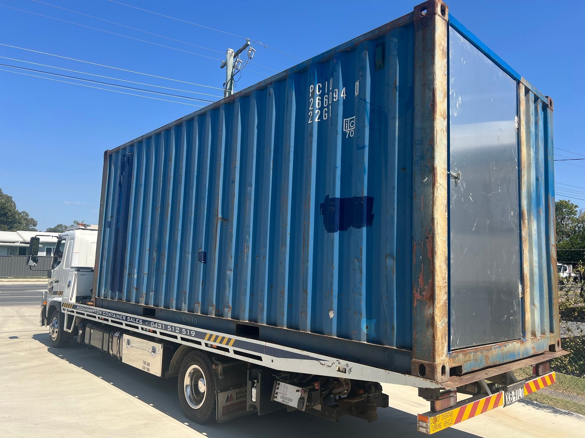 Blue Shipping Container Loaded on a Flatbed Truck Outdoors on a Sunny Day  — Rockhampton Container Sales in Kawana, QLD