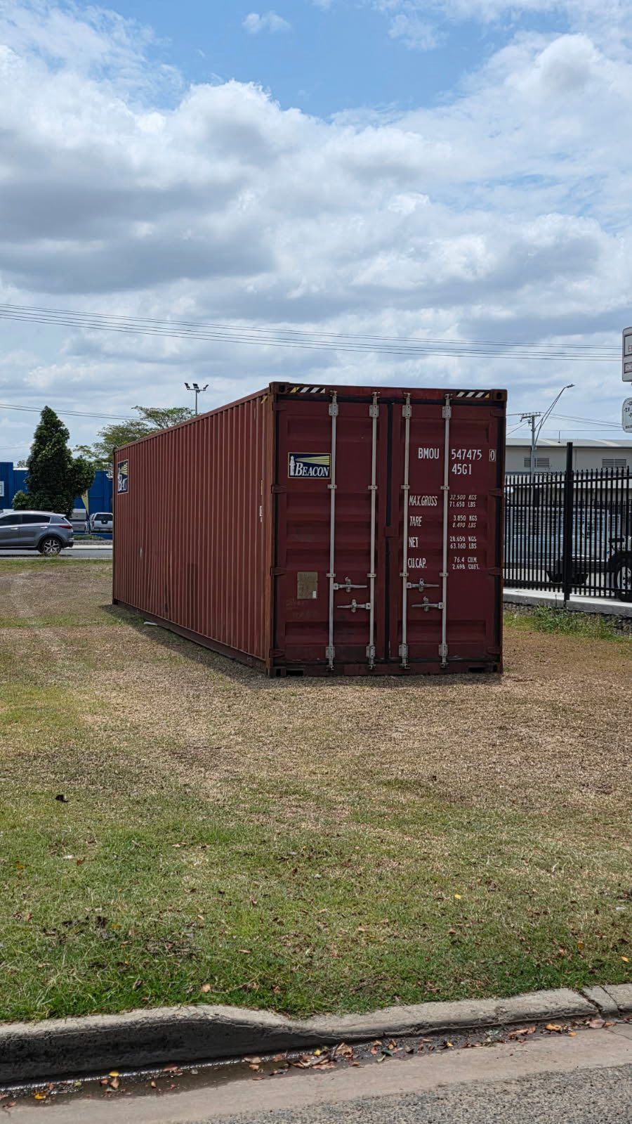 Red Shipping Container on a Grassy Area  — Rockhampton Container Sales in Kawana, QLD