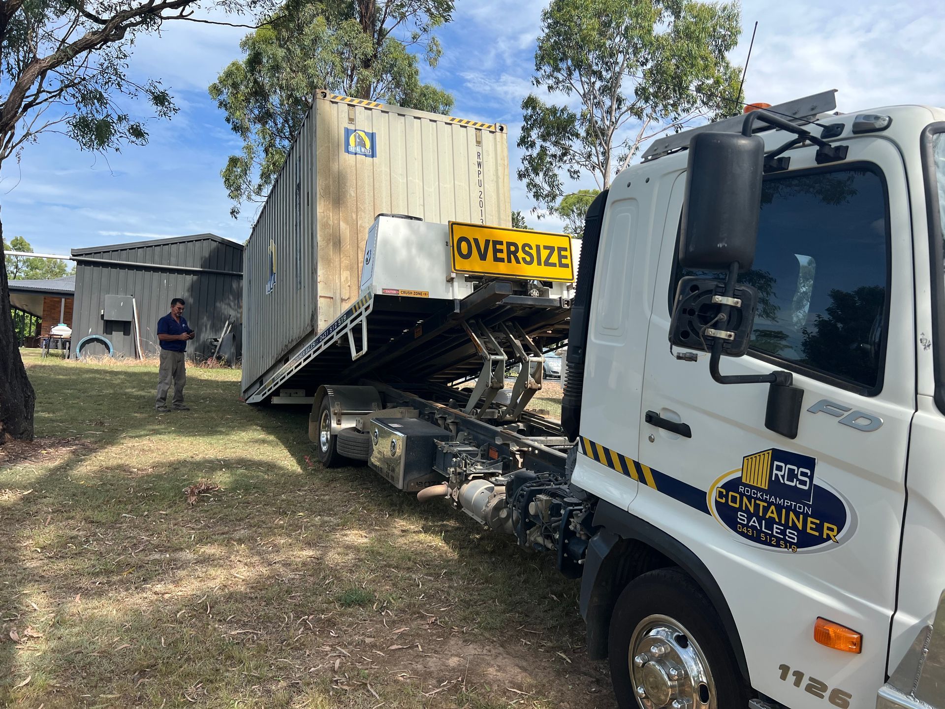 White Shipping Container on a Flatbed Truck in Bright Sunlight — Rockhampton Container Sales in Kawana, QLD