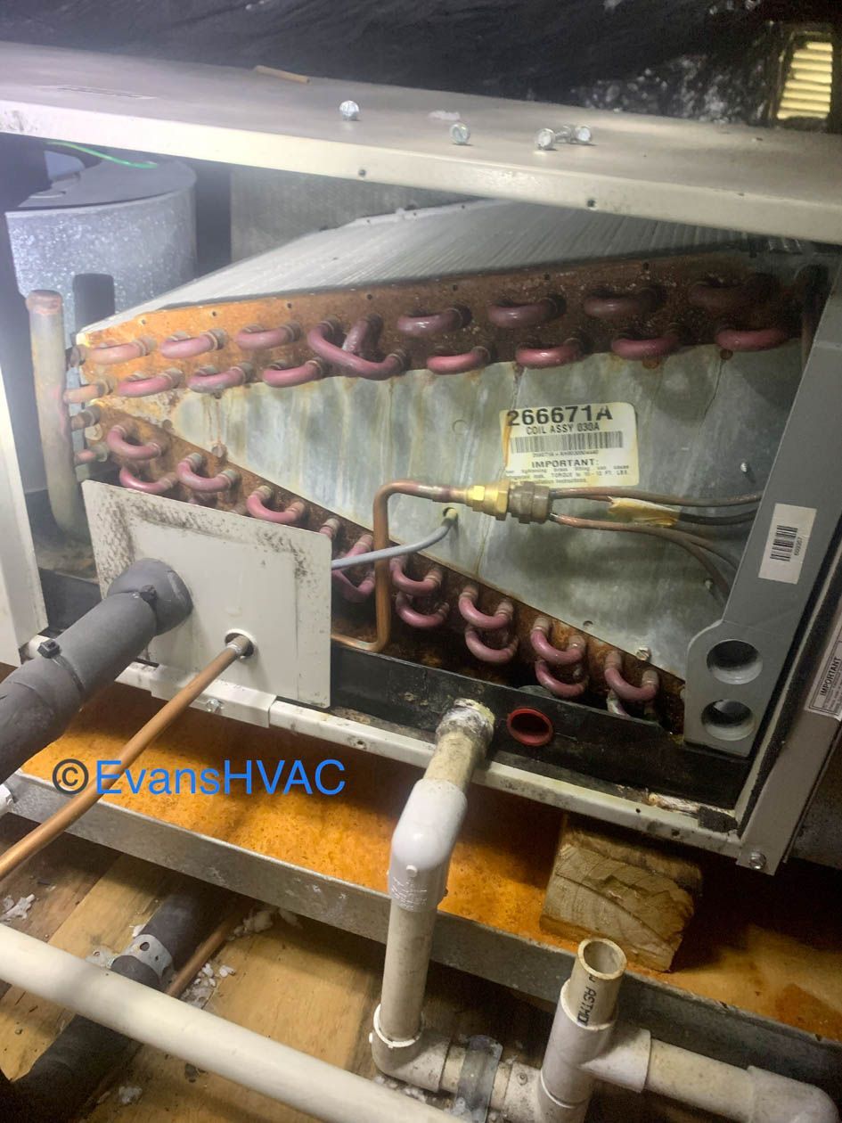 The inside of an air conditioner with a lot of pipes coming out of it.