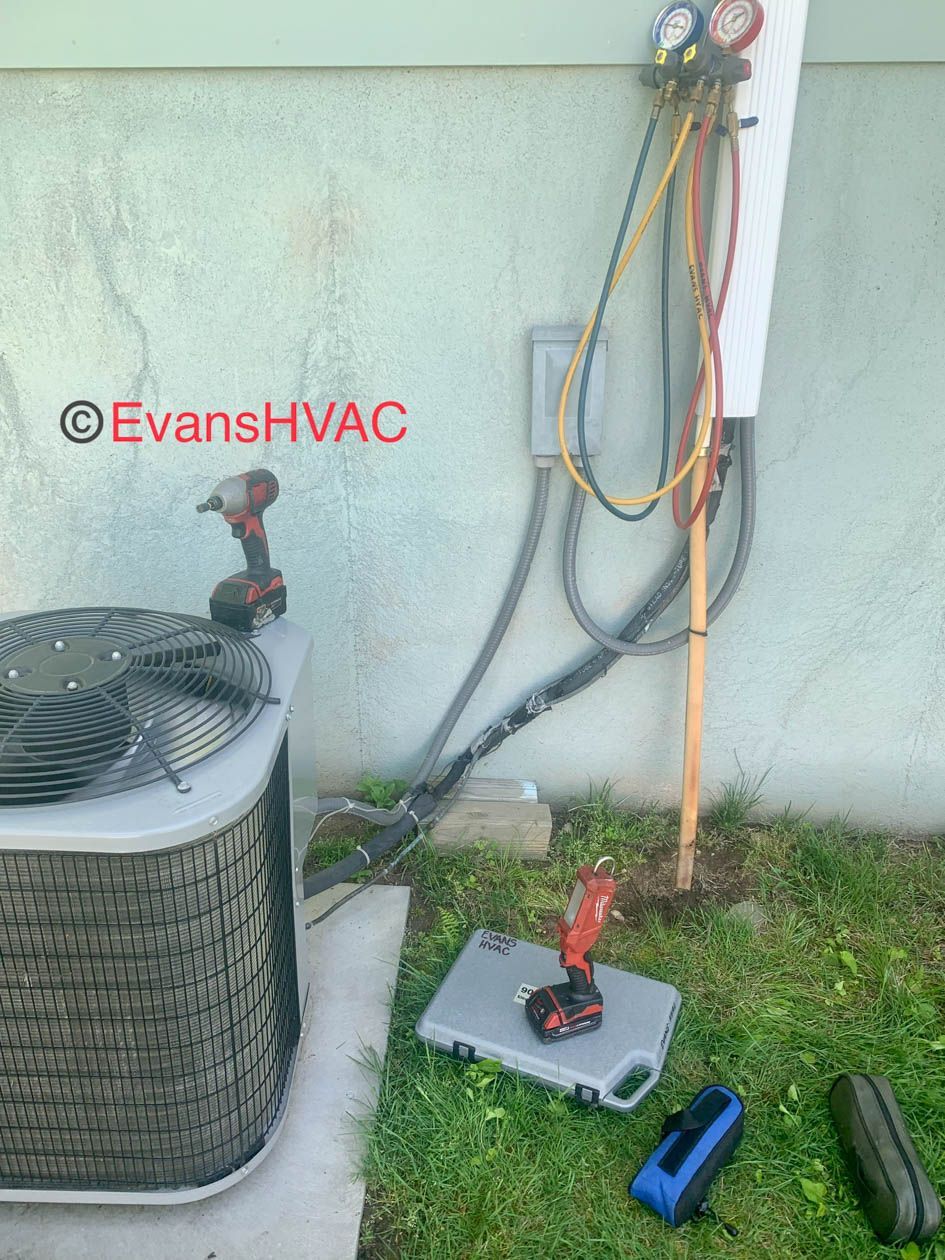 An air conditioner is being serviced by evans hvac
