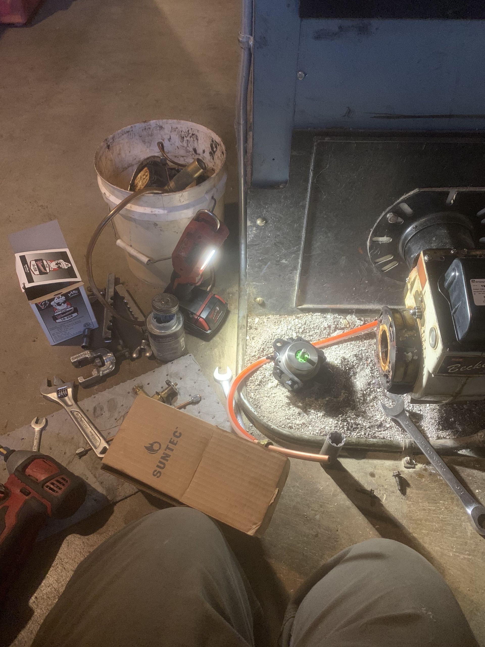 A person is sitting on the floor next to a bucket of keys.