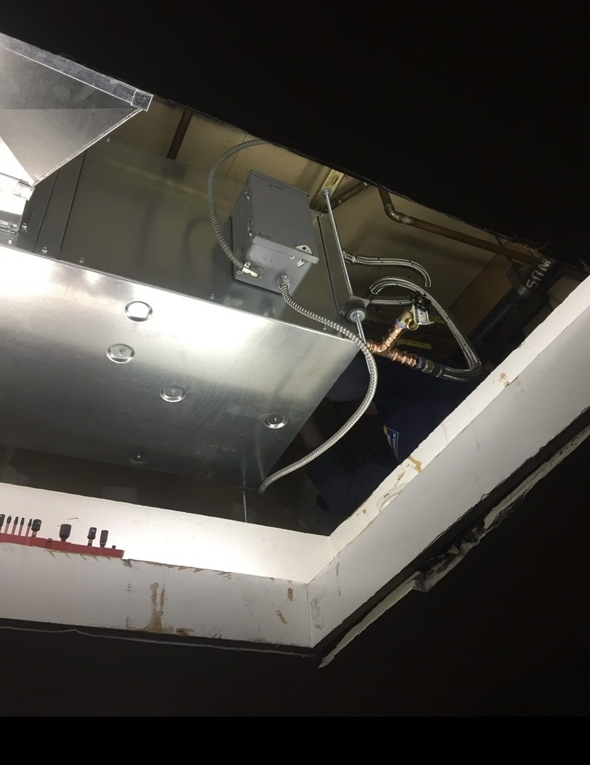 A ceiling with a lot of wires coming out of it.