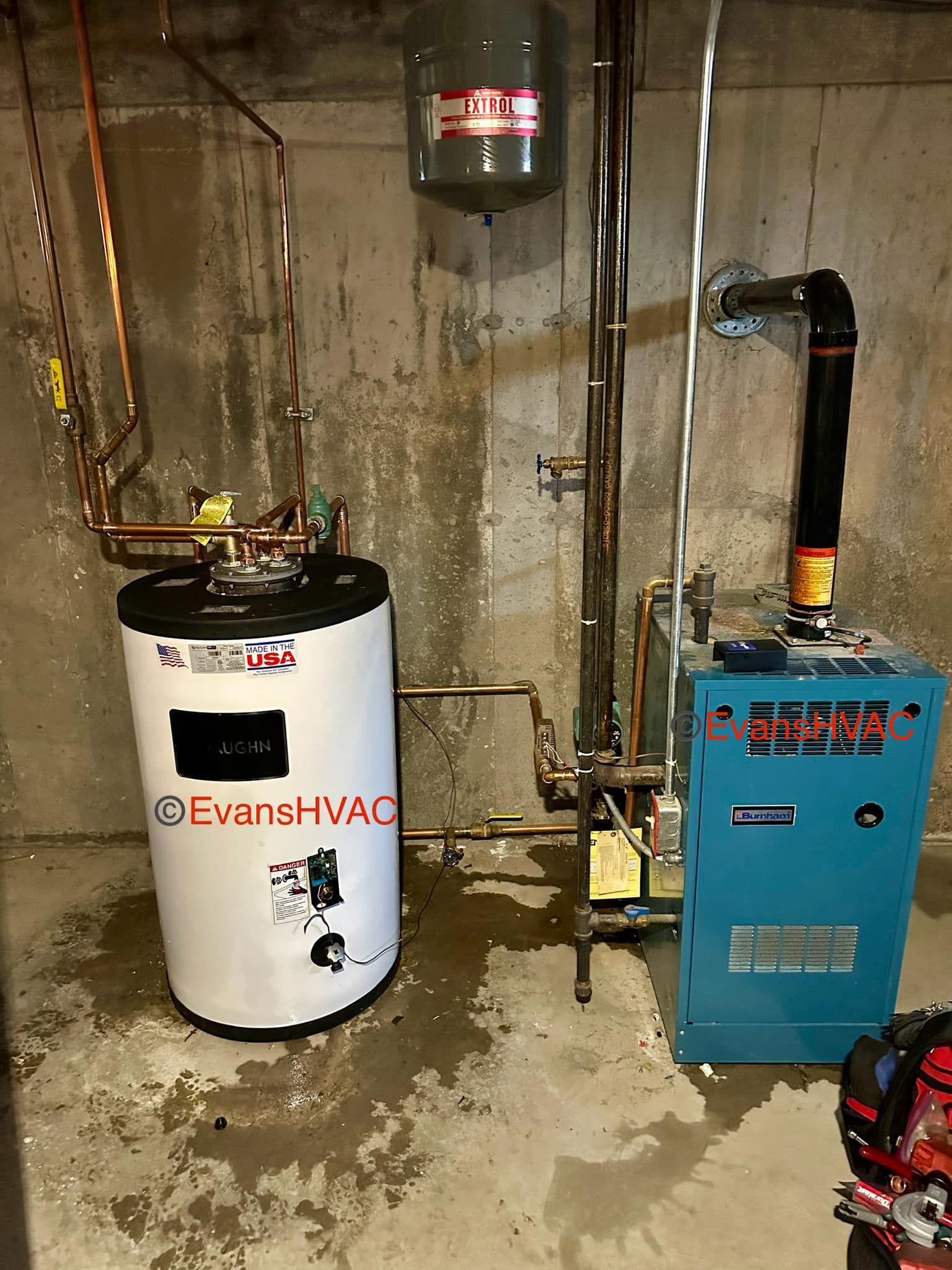 A water heater is sitting next to a blue boiler in a basement.