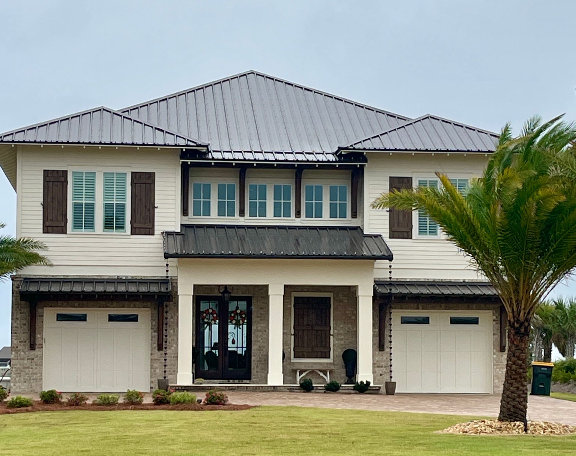 A large white house with a palm tree in front of it