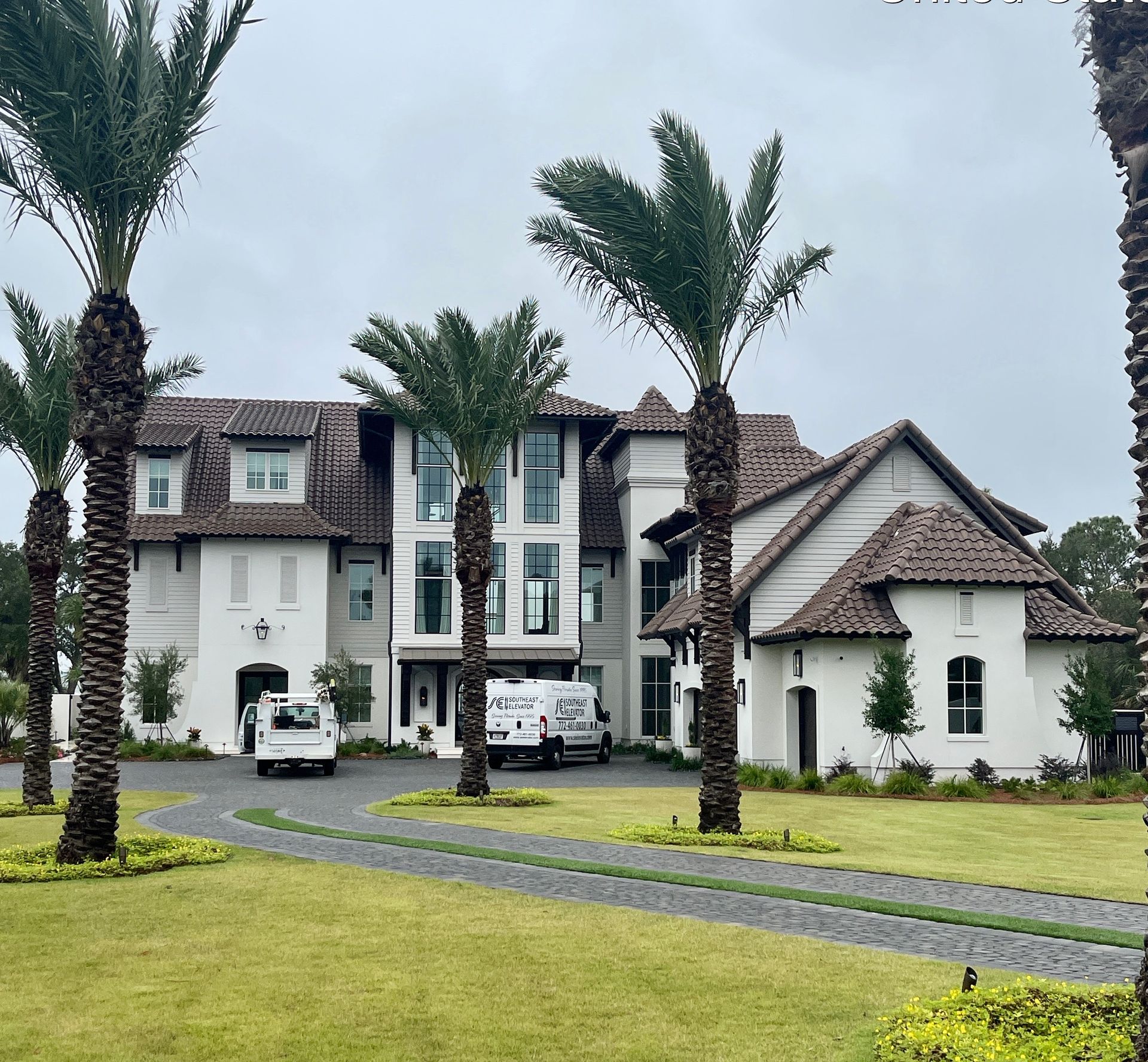 A large white house with palm trees in front of it