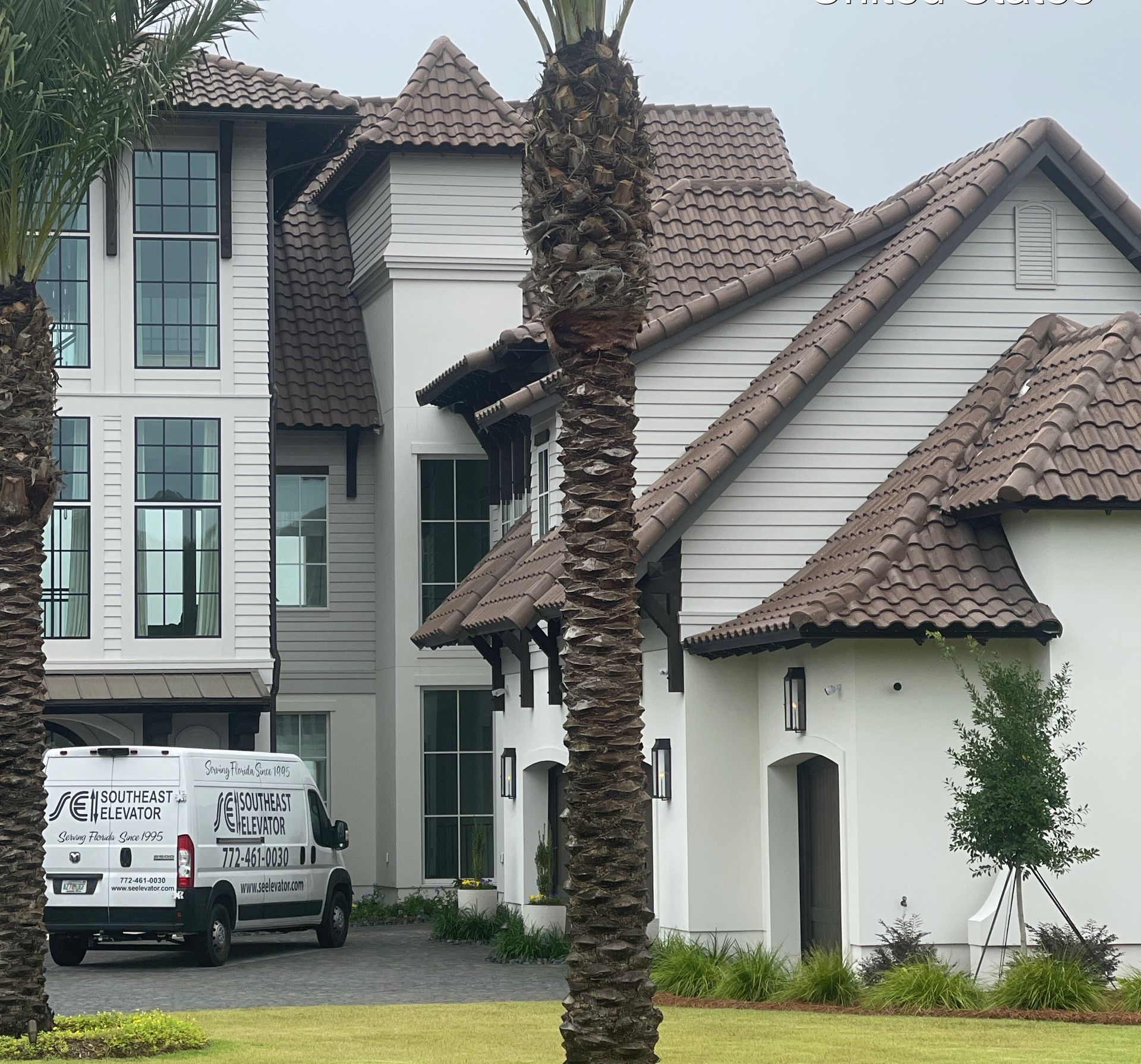 A large white house with a white van parked in front of it