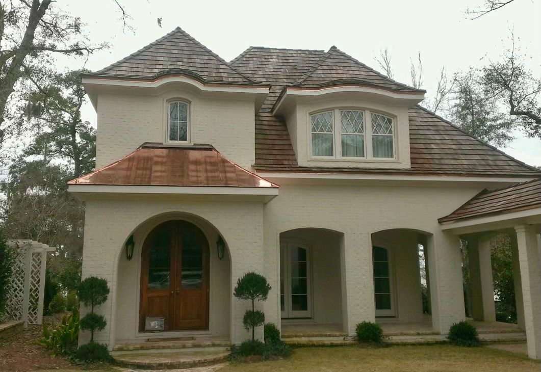 A large white house with a copper roof