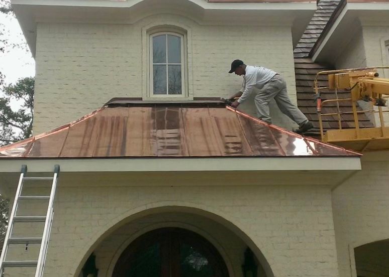 A man is working on the roof of a house