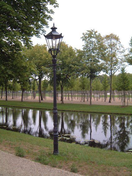 Ein Laternenpfahl in einem Park neben einem Gewässer