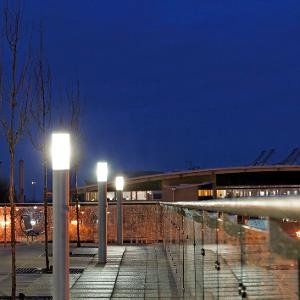 Eine Brücke mit einem Glasgeländer und Beleuchtung bei Nacht.