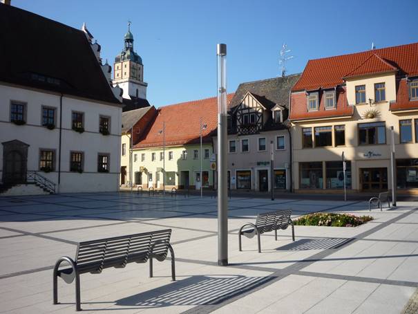 Ein Stadtplatz mit einem Uhrturm im Hintergrund