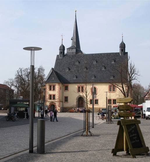 Ein großes Gebäude mit einem Kirchturm in der Mitte eines Platzes