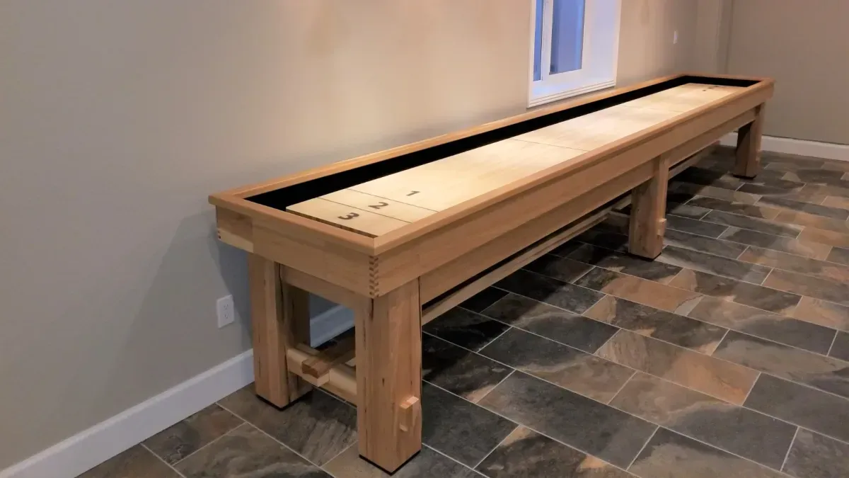 Shuffleboard table in a room with wood flooring.
