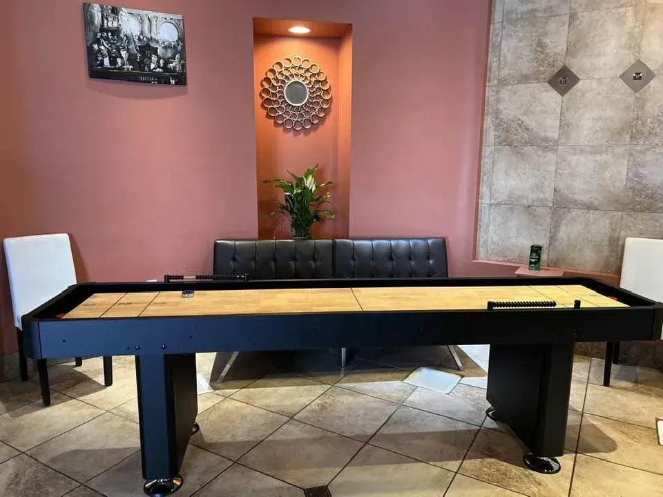 Shuffleboard table in a room with seating and decor.