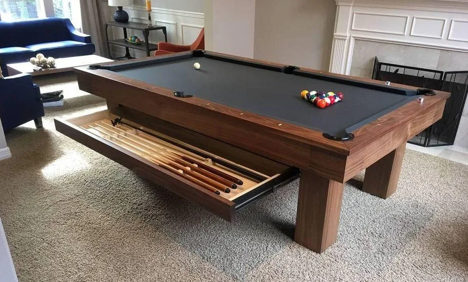 Pool table with a drawer holding pool cues, set in a living room.