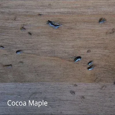 Close-up of Cocoa Maple wood grain, with small, dark spots and highlights.