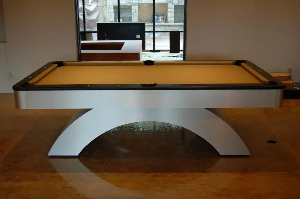Modern silver pool table with tan felt, indoors.