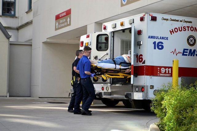 A man on a stretcher is being loaded into an ambulance.