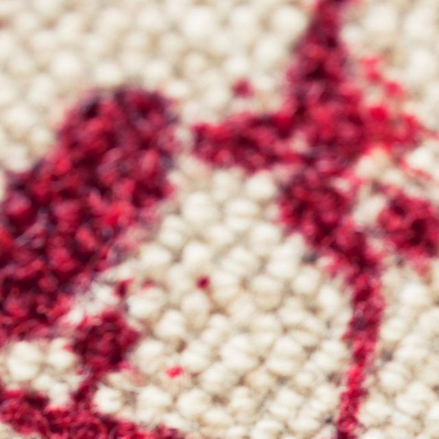 A close up of a rug with a red heart on it.