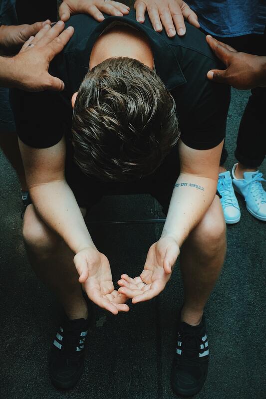 A man is kneeling down in a circle with his hands outstretched.