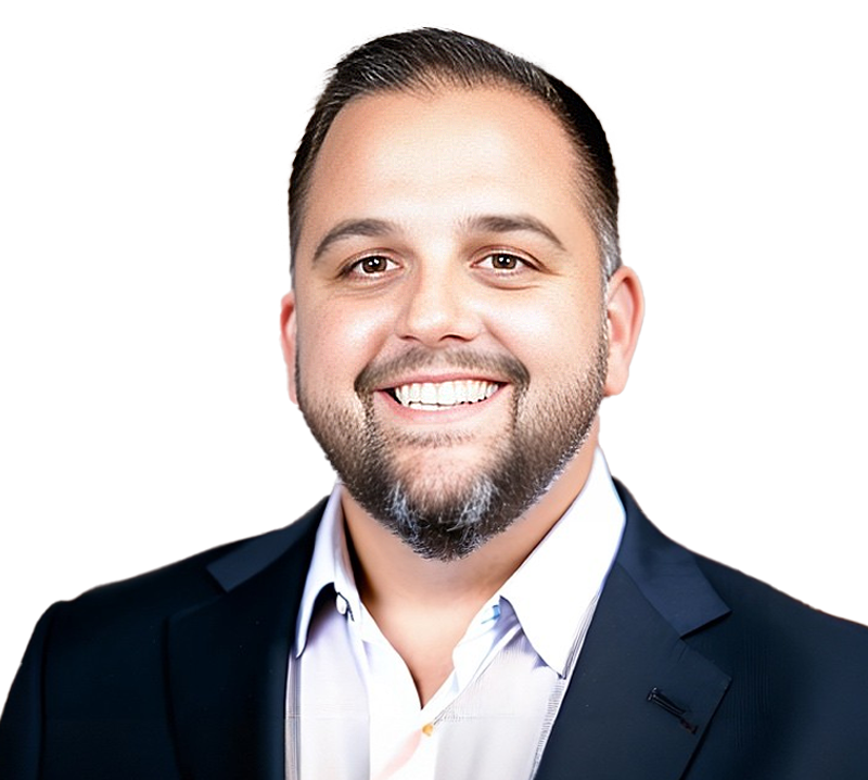 Tony Busquets, CFO, with dark hair and beard smiling, wearing a blue blazer over a white shirt.