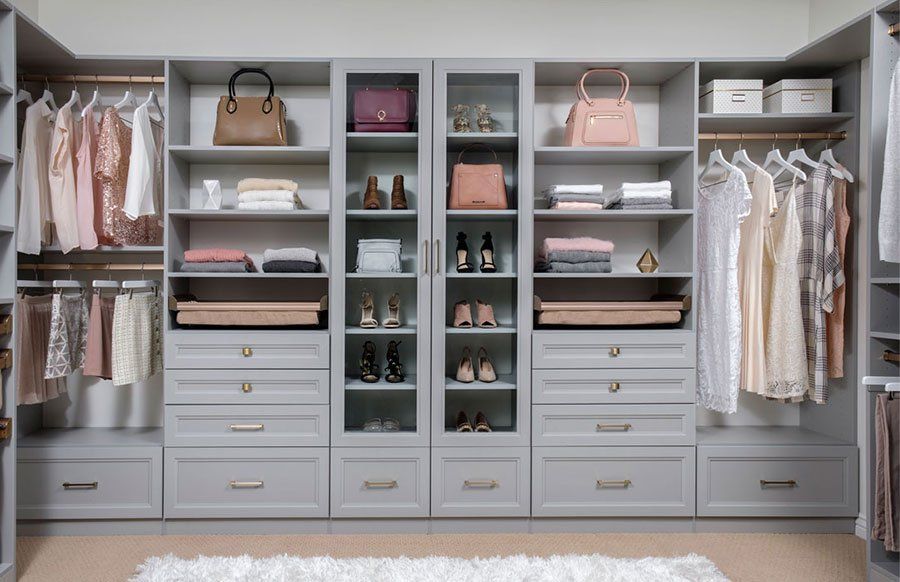 a walk in closet filled with lots of clothes and shoes .