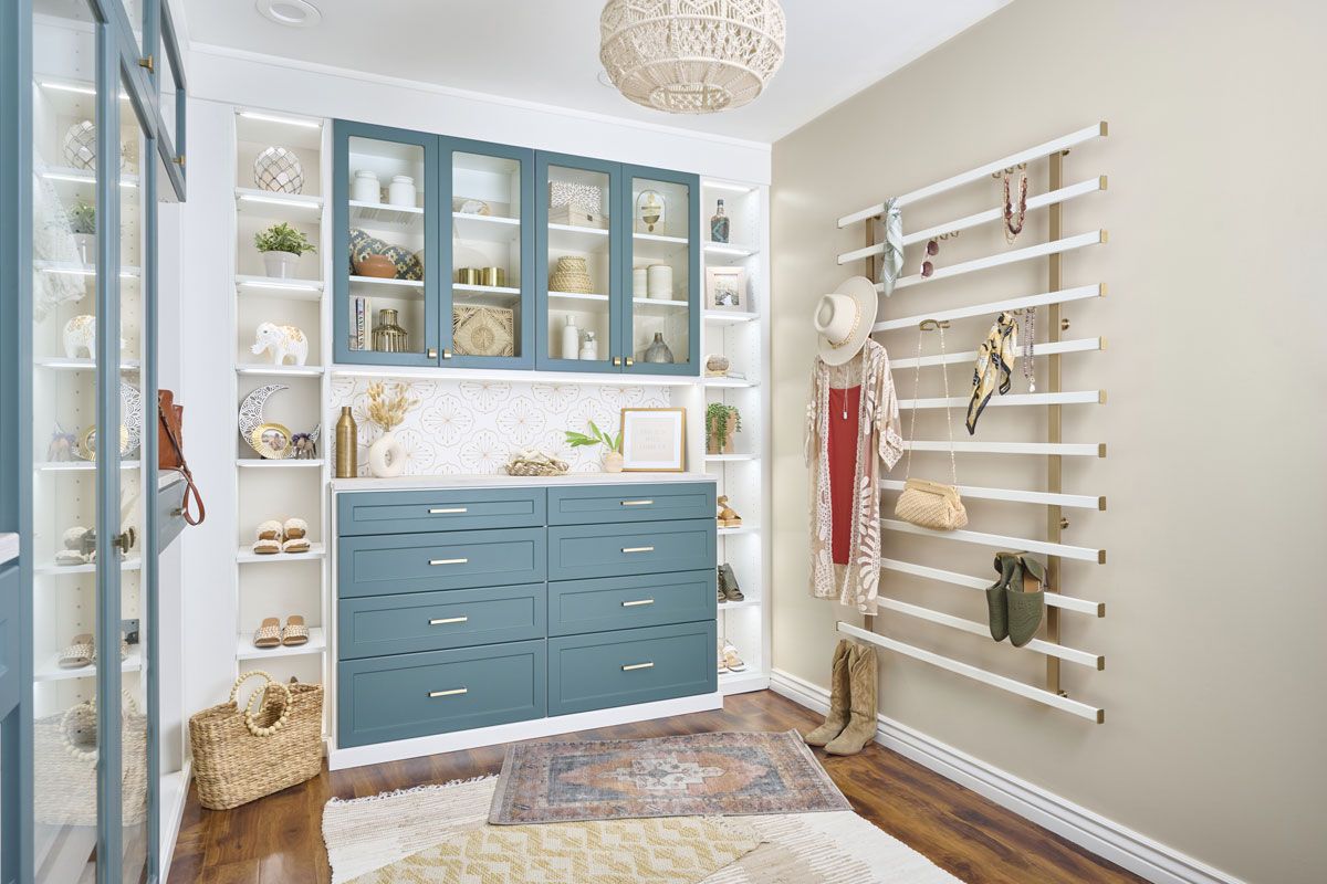 a walk in closet with lagoon cabinets and white shelves .