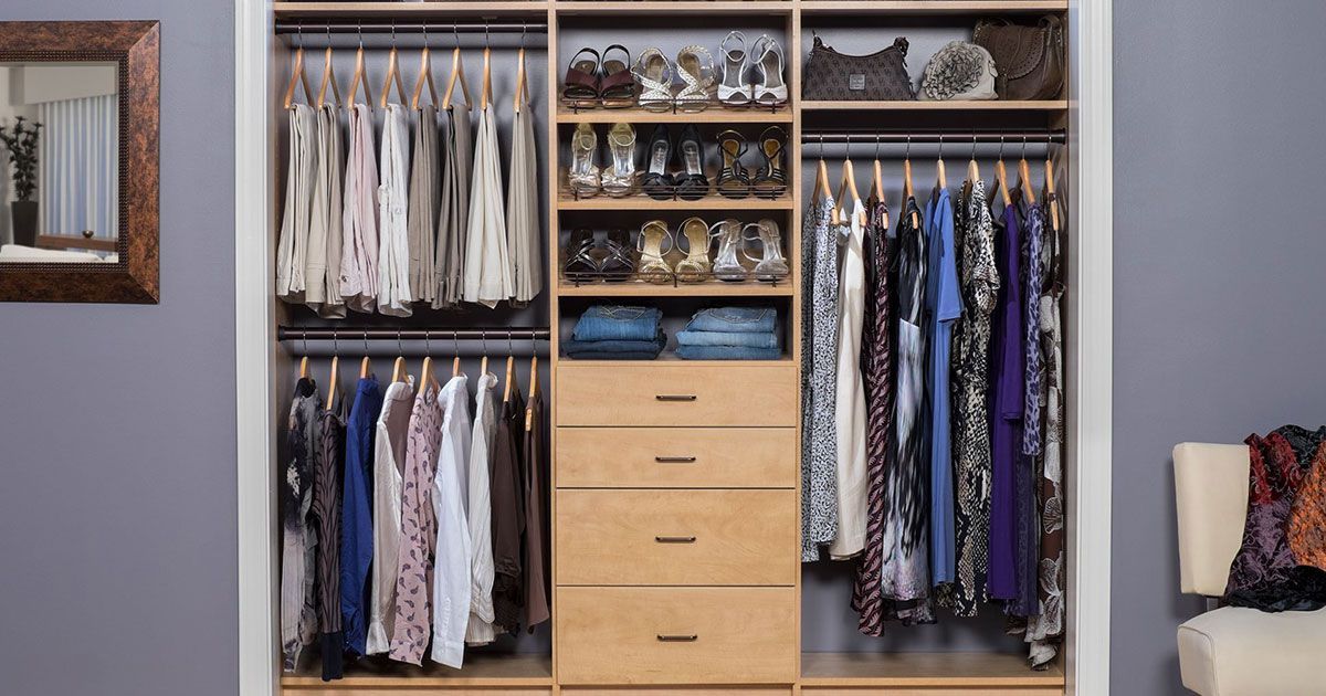 a closet filled with lots of clothes and shoes .