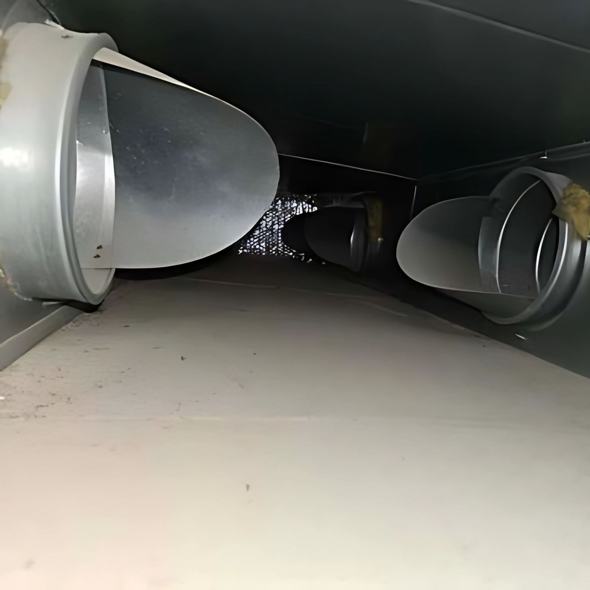 Inside of an HVAC duct with three metal air vents visible.