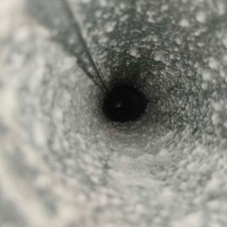 Duct Wrangler, LLC - A man is working on a ventilation system in a building.