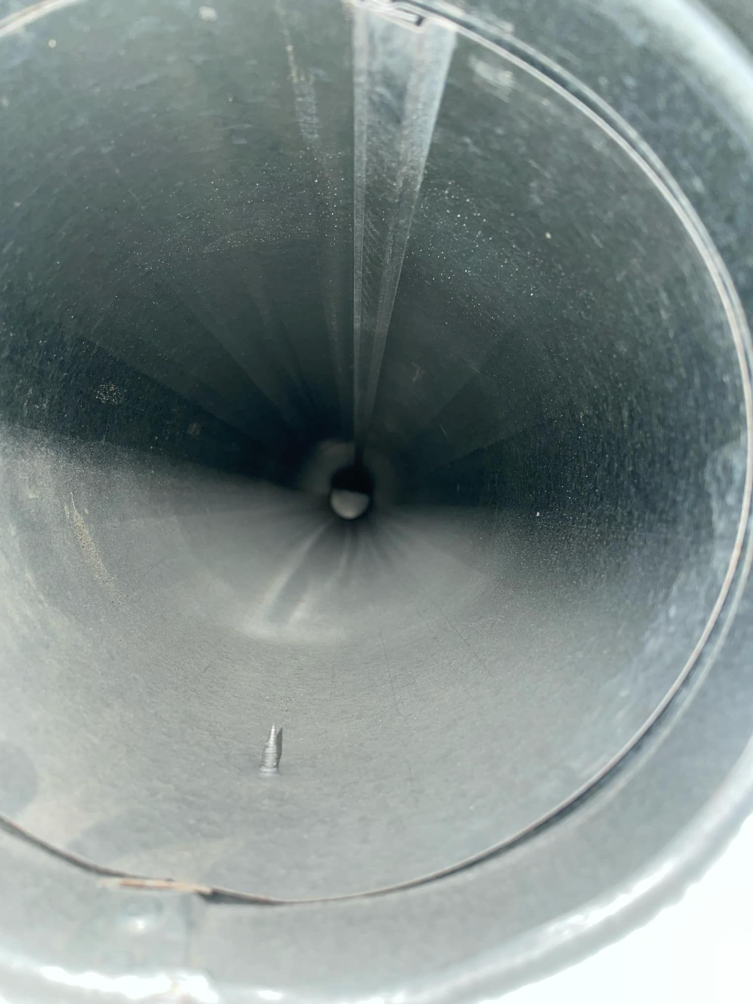 A close up of a metal pipe with a hole in the middle.