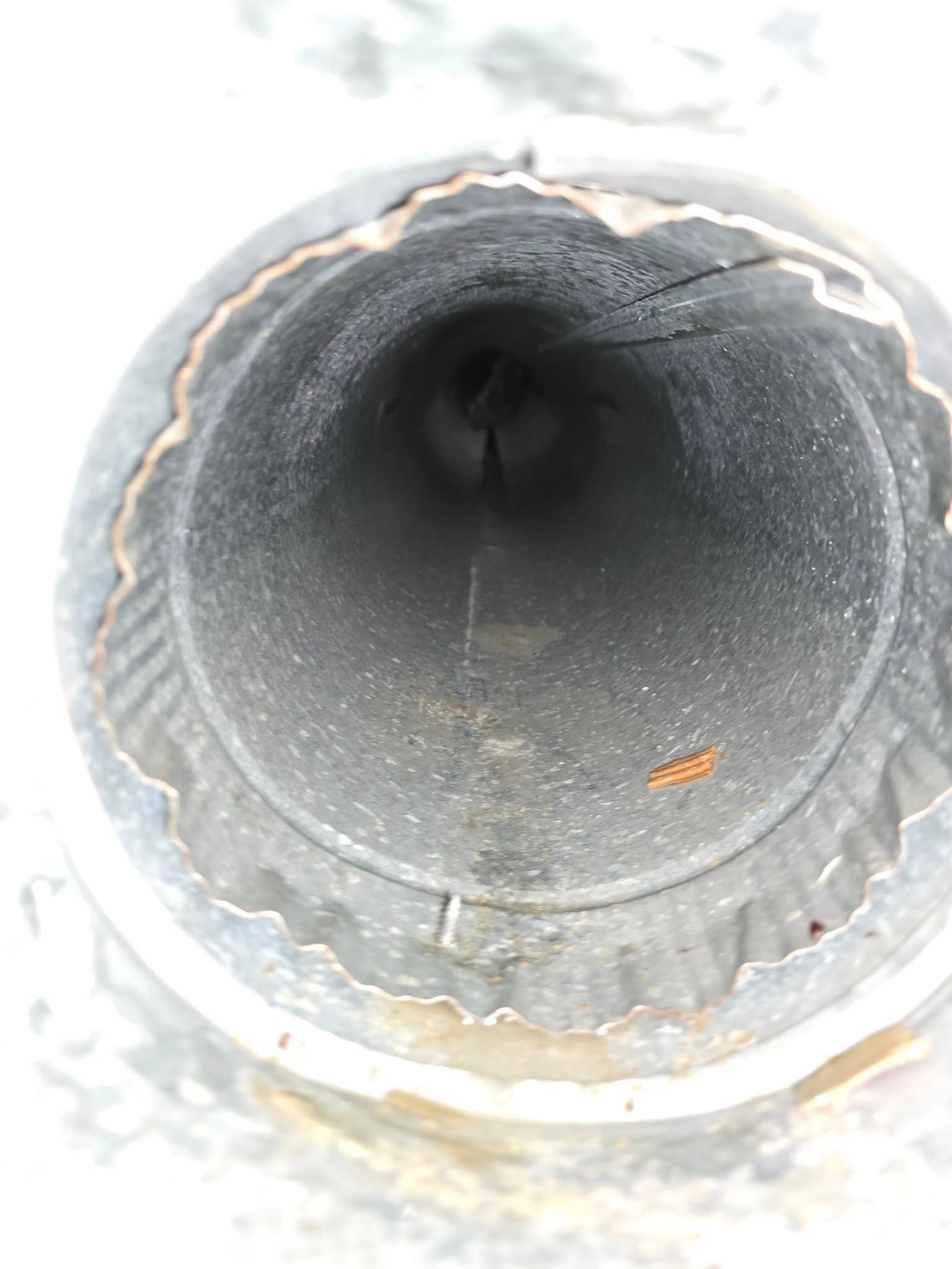 A close up of a metal pipe with a hole in the middle.