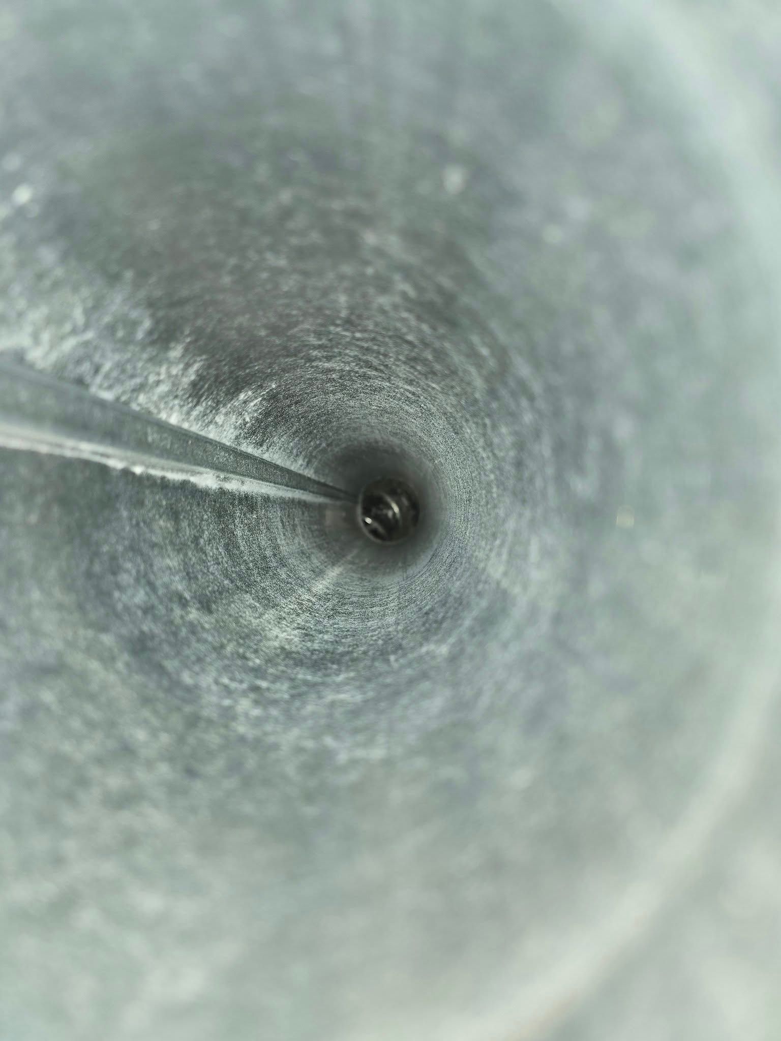 A close up of a metal pipe with water coming out of it.