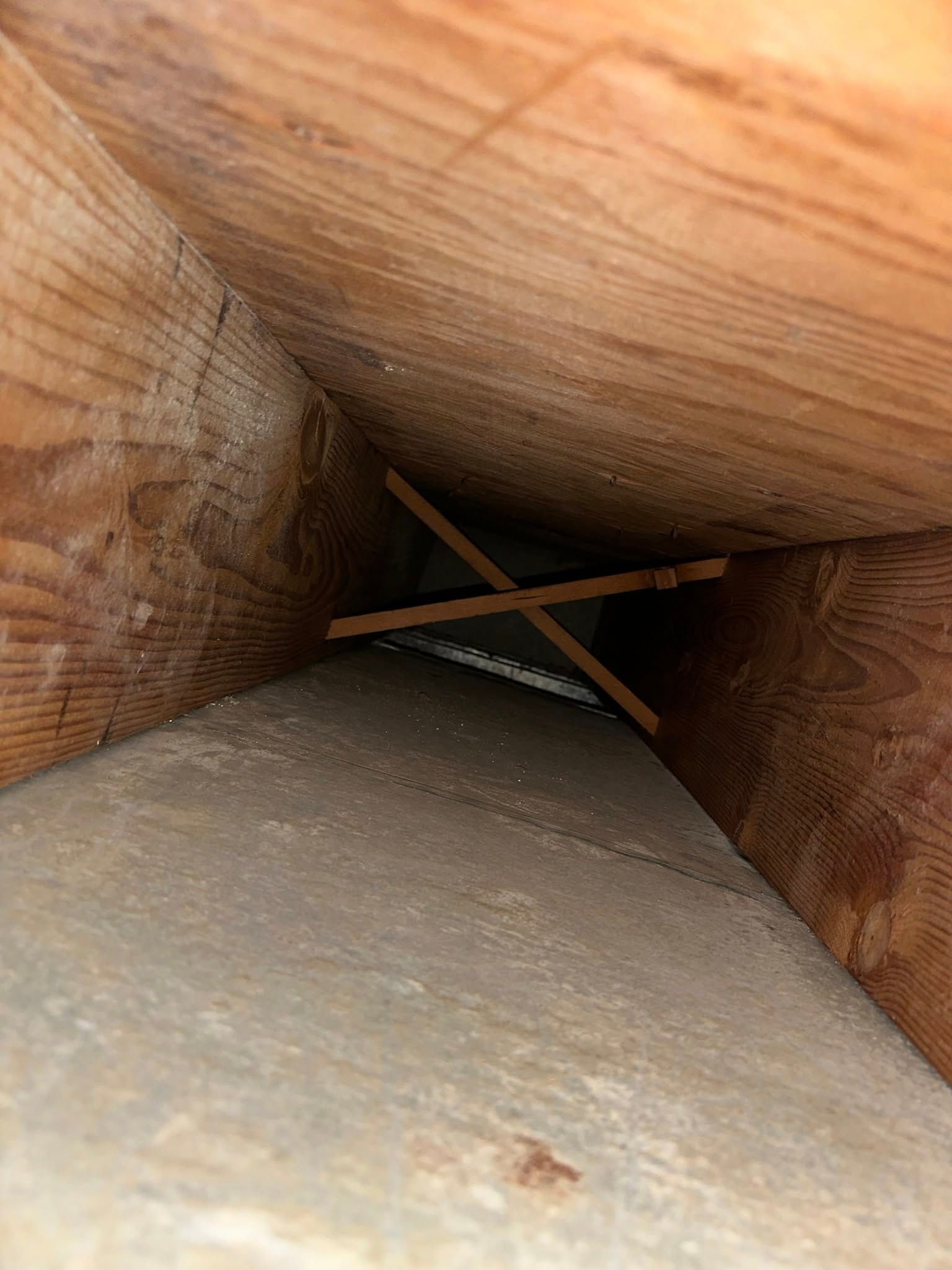 A close up of a hole in a wooden structure.