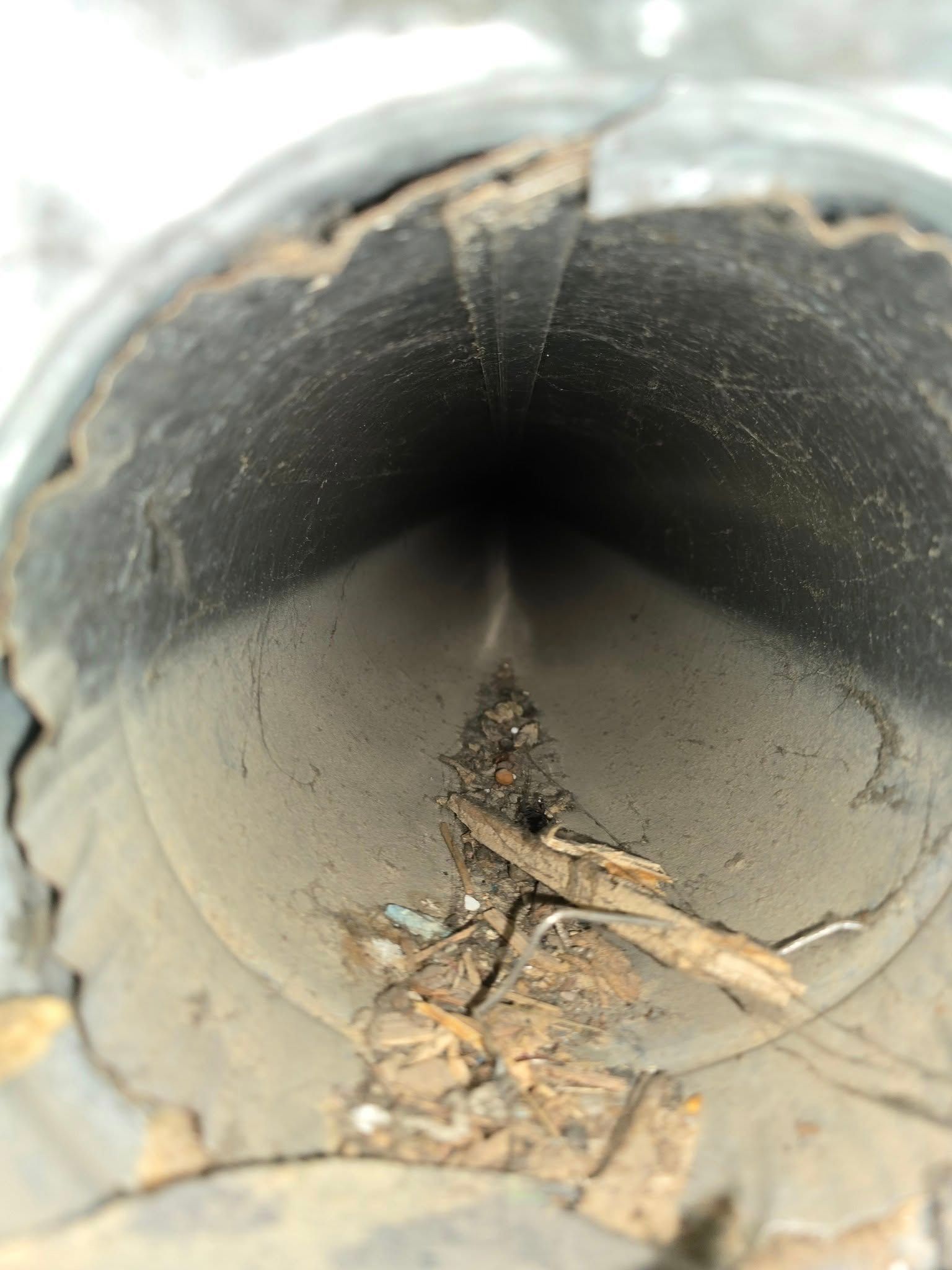 A close up of a dirty pipe with a hole in the middle.