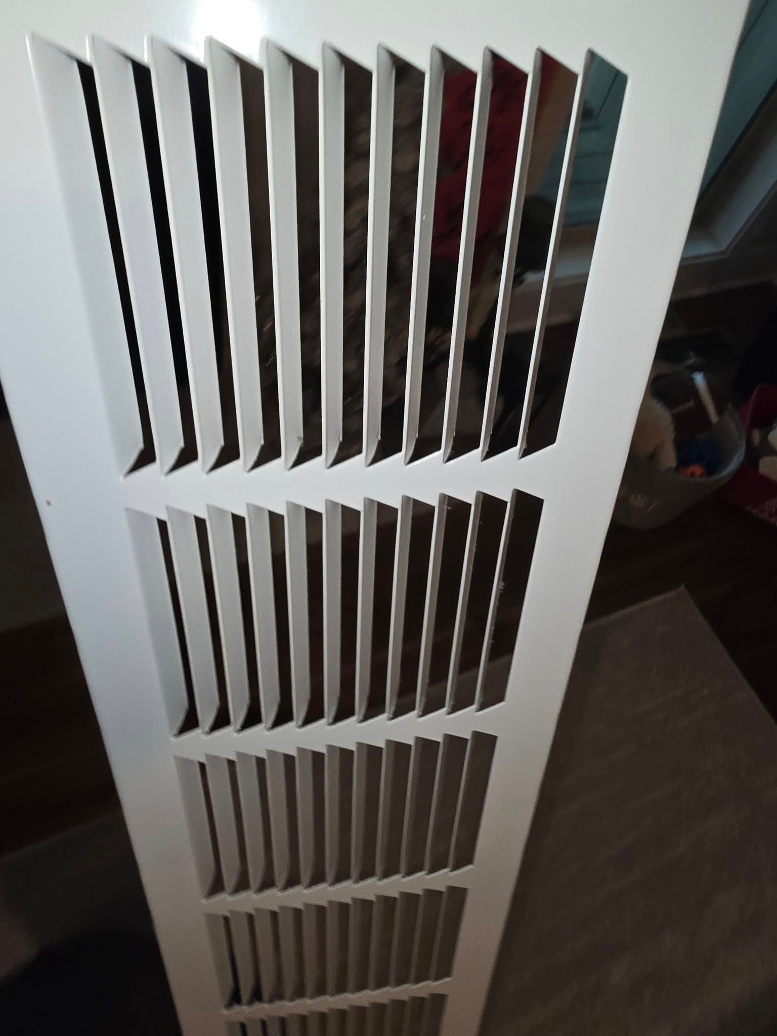 A white air vent with a lot of holes in it
