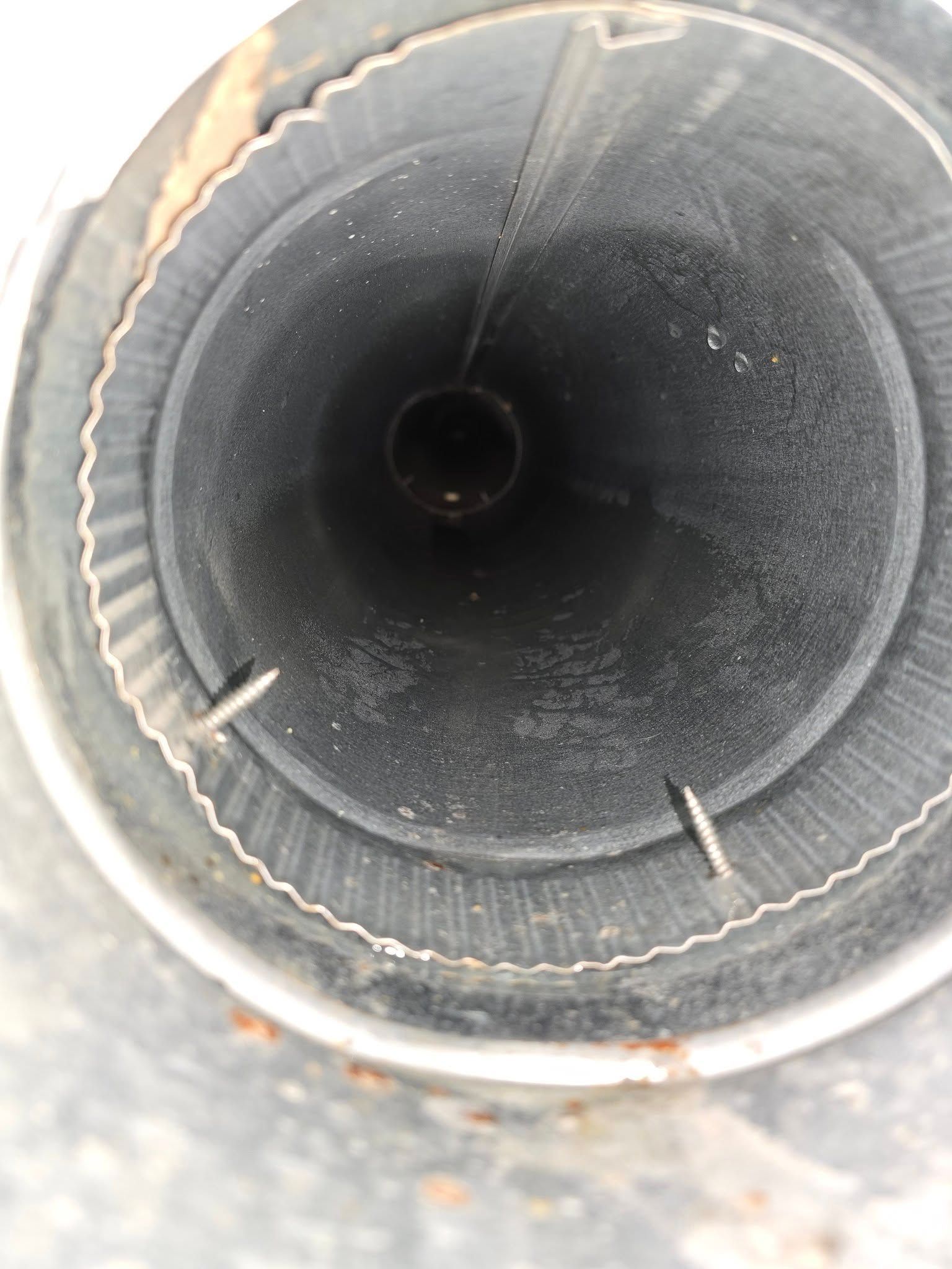 A close up of a metal pipe with a hole in the middle.