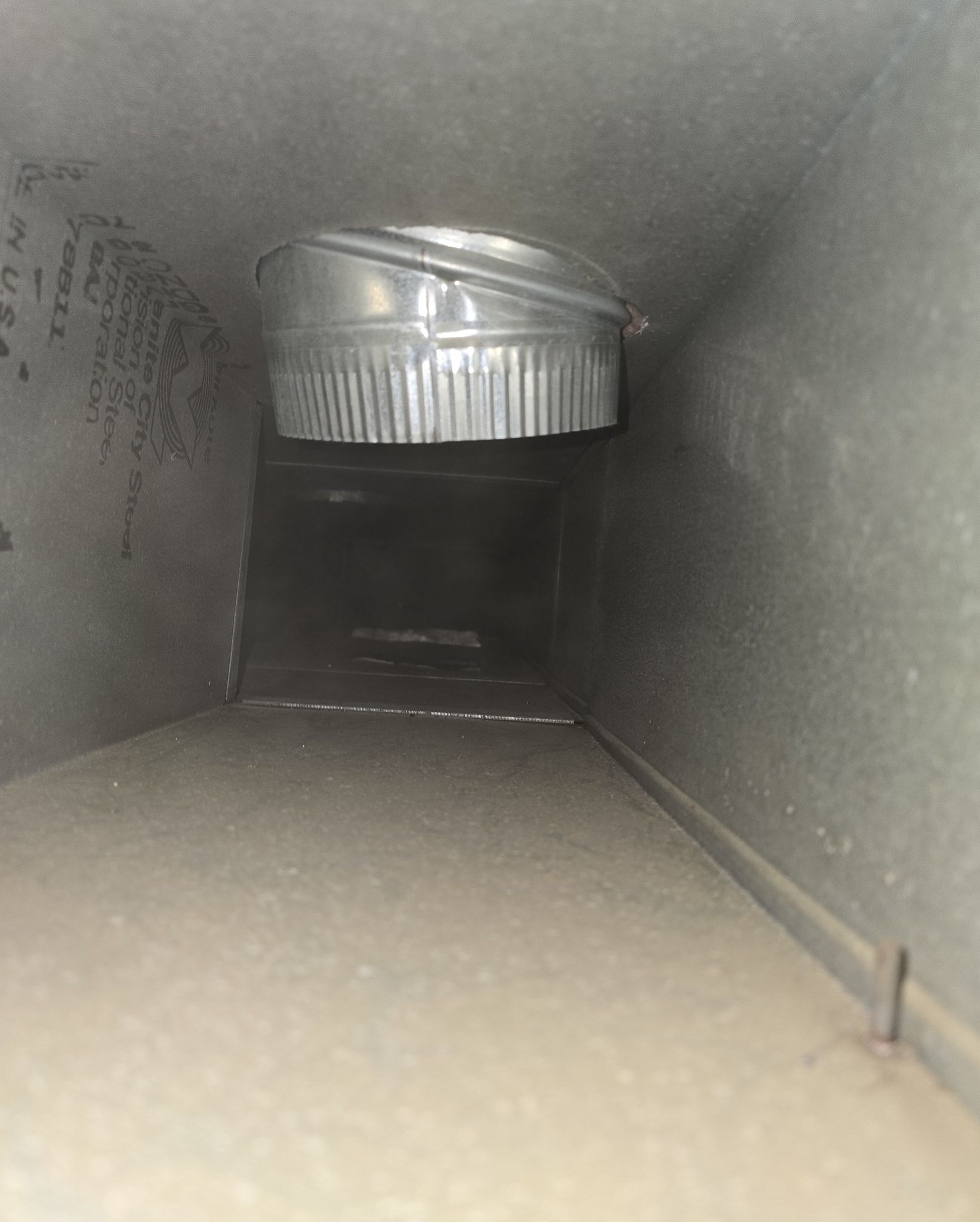 A close up of a metal duct in a room.
