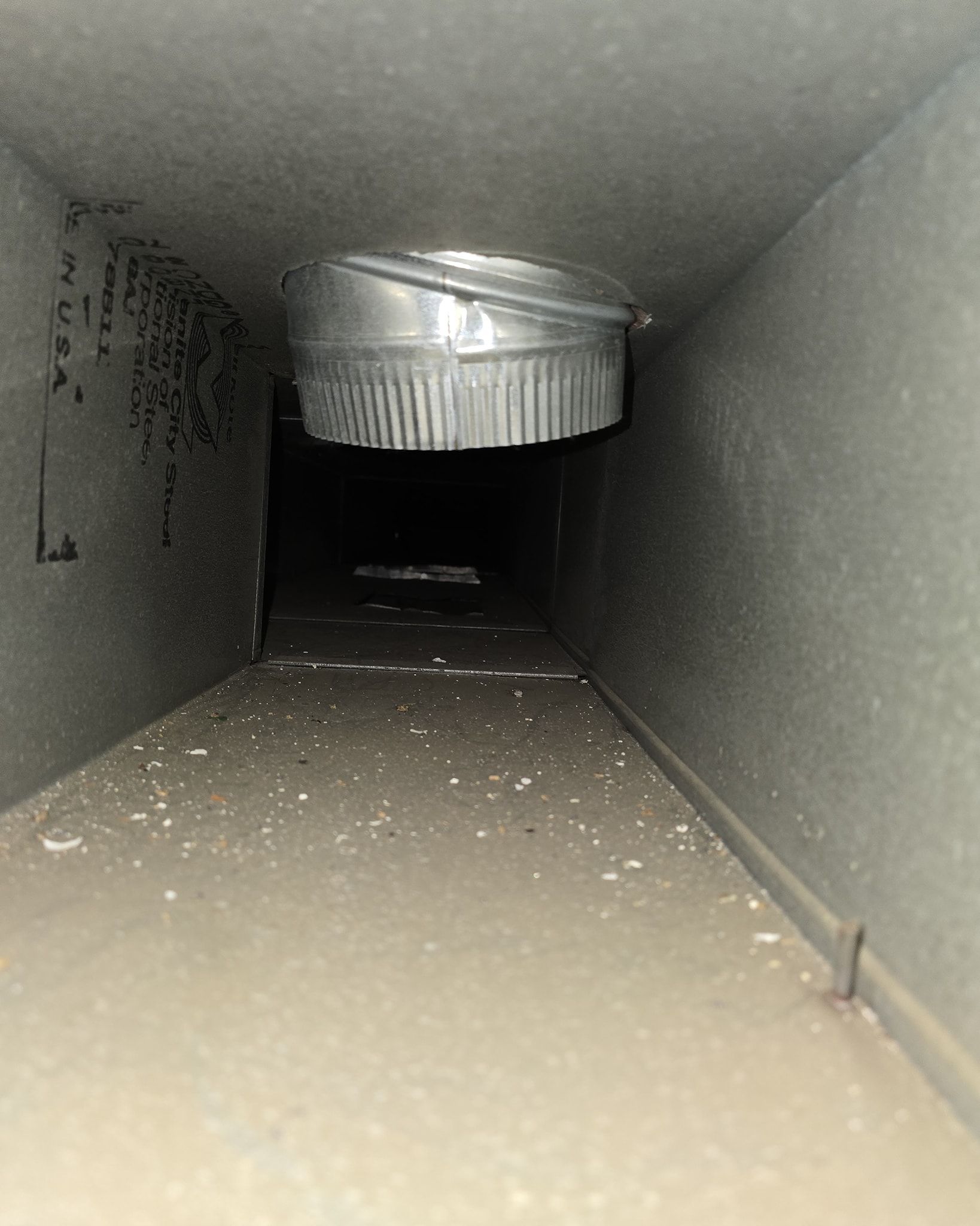 A close up of a duct with a metal ring in the middle of it.