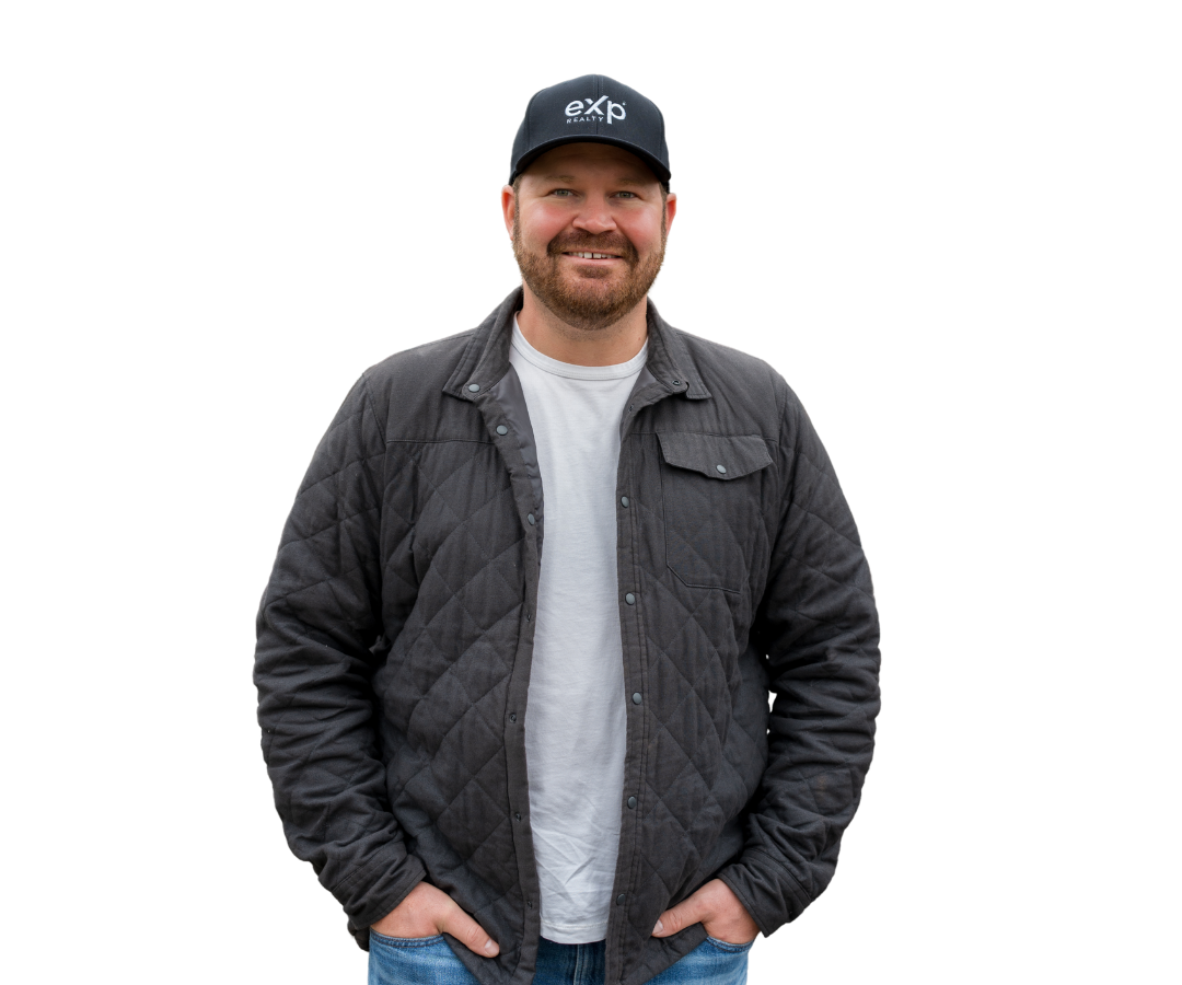 A man in a black polo shirt is standing with his arms outstretched
