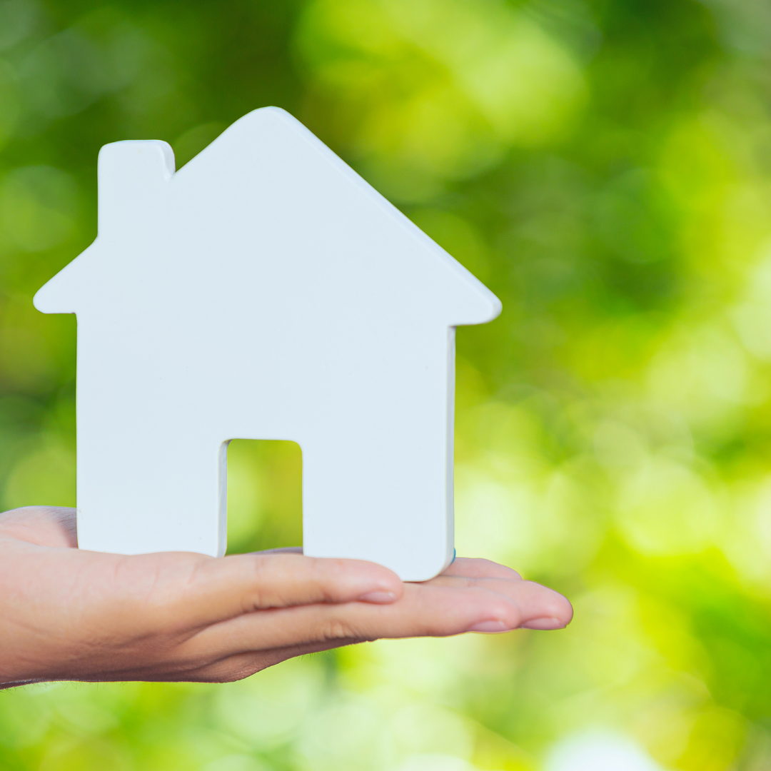 A person is holding a white house in their hand.