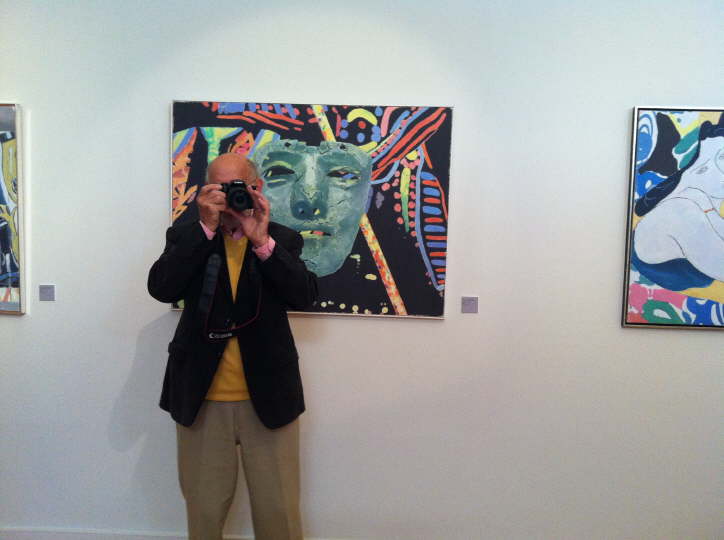 Ein Mann, der mit einer Kamera ein Foto von einem Gemälde macht