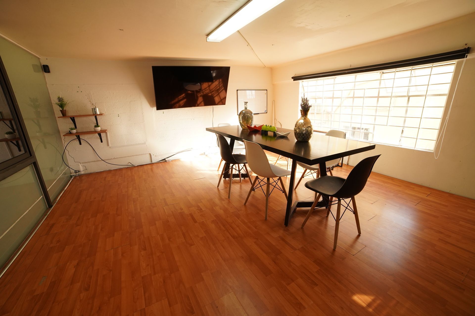Un comedor con una mesa y sillas y un televisor en la pared.