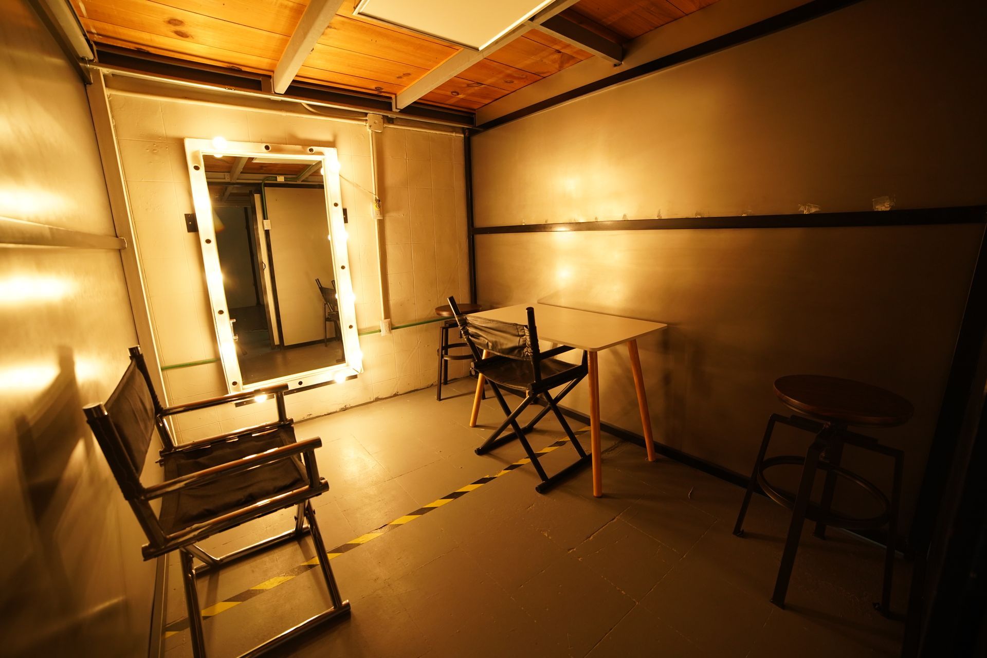 Una habitación con sillas, una mesa y un espejo.